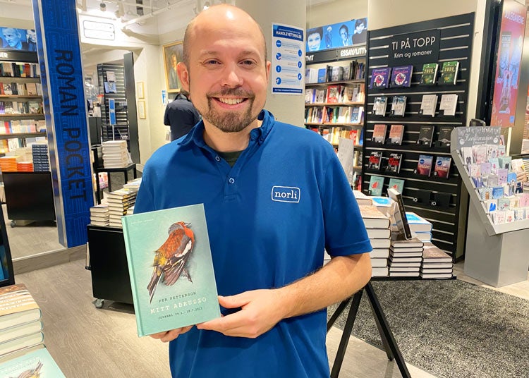 Butikksjef Iver holder bok av Per Petterson