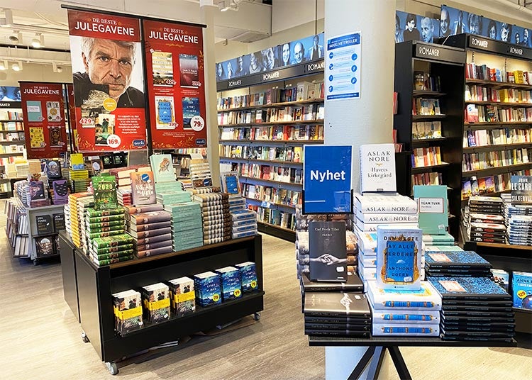 Bilde fra inngangspartiet i Norli Universitetsgata. Bildet viser to bord med bøker utstilt, i bakgrunnen står det fulle bokhyller.