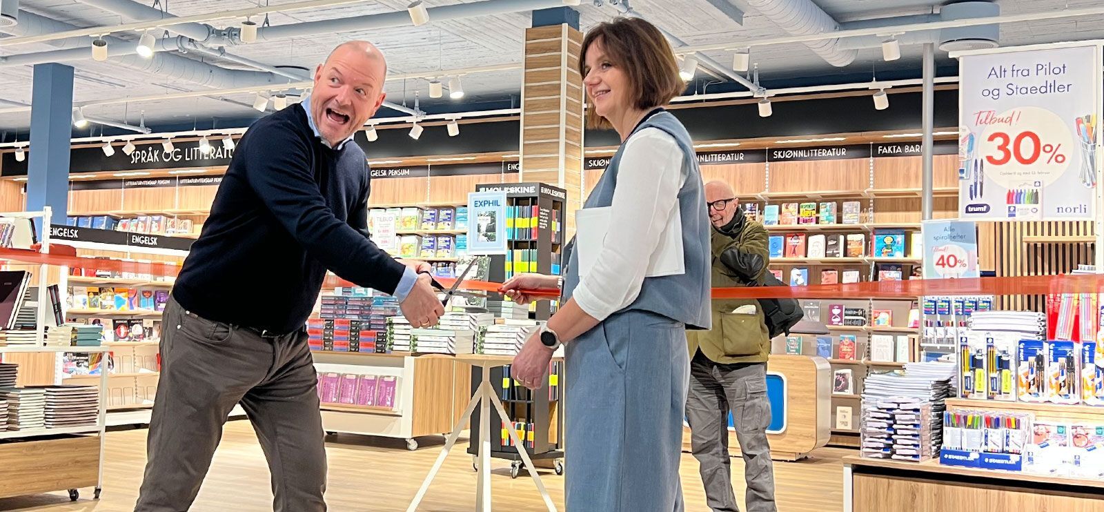 Norli-direktør Johan Baklund klipper snoren sammen med prorektor Åse Gornitzka.