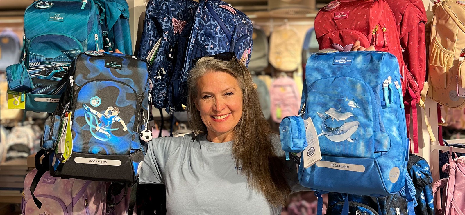 Beckmann 1. klassesekk: Butikksjef på Norli Paleet holder sekkene Magic League og Ocean. Sekkene passer for alle barn.