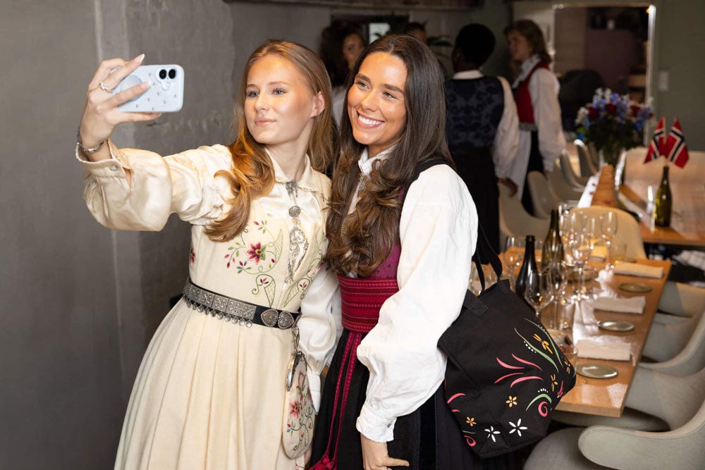 To jenter som tar selfie i bunad