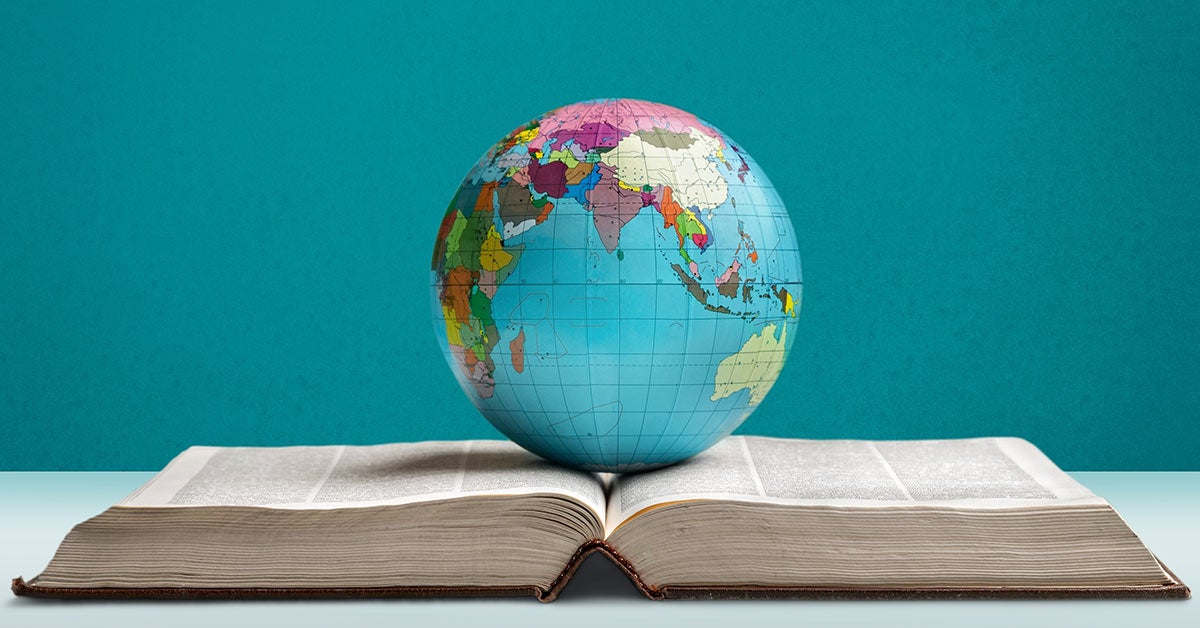 Jordklode på toppen av en åpen bok. Illustrerer at en bok kan åpne opp for verden.