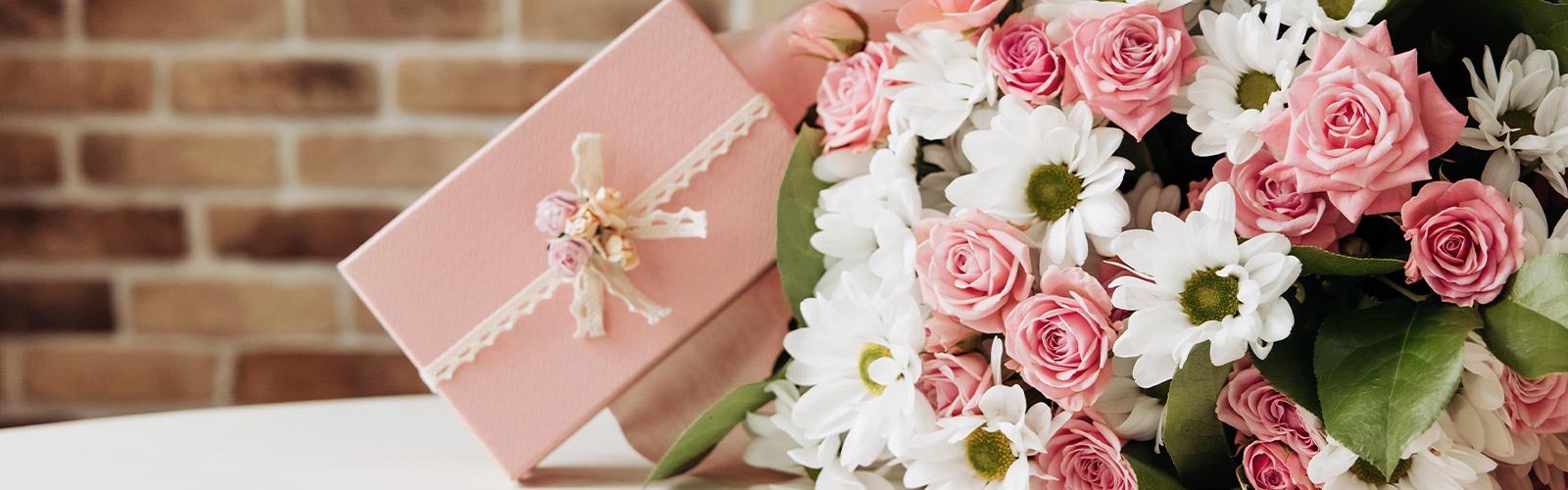 Liten rosa gave og blomsterbukett