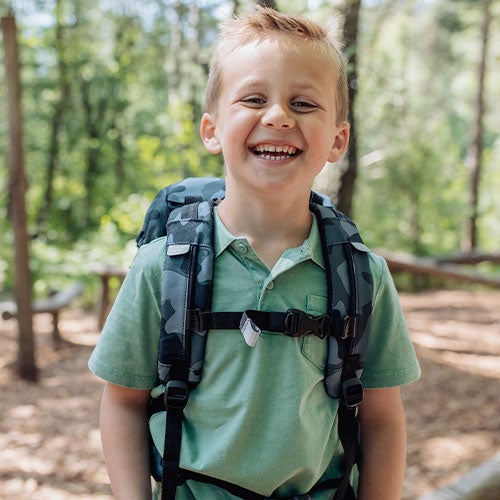 Smilende gutt med sekk