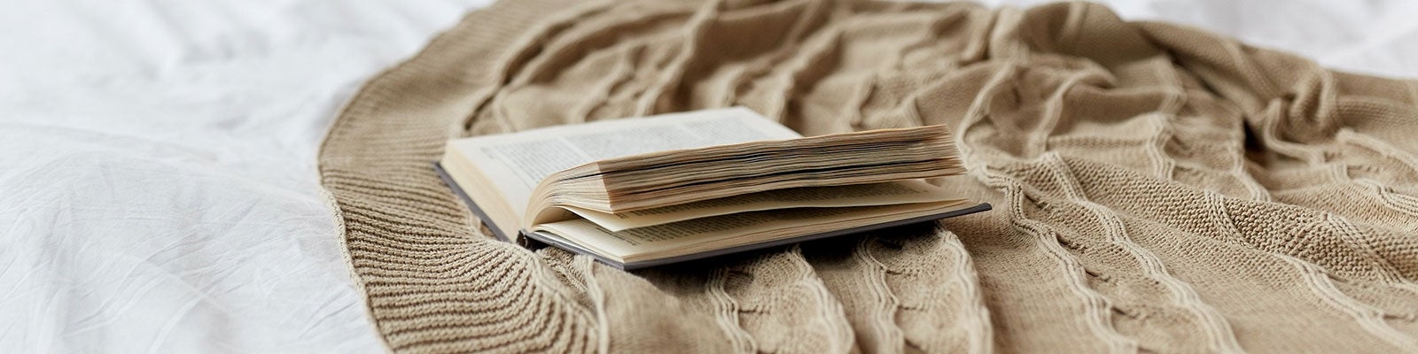 åpne bok på seng